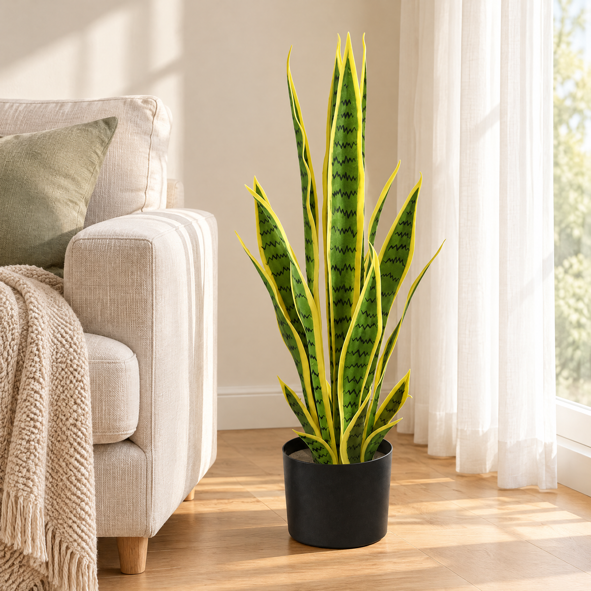 Faux snake plant in a black pot beside a linen sofa in a bright Scandinavian living room