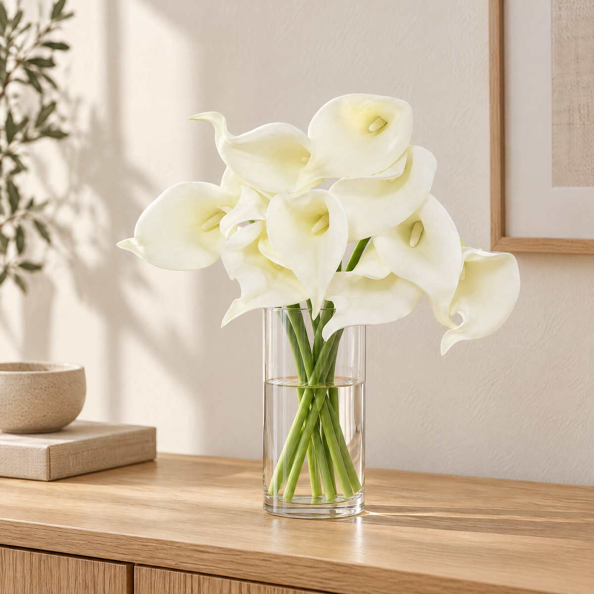 Calla Lily Stems Margita – in a tall glass vase on an oak console