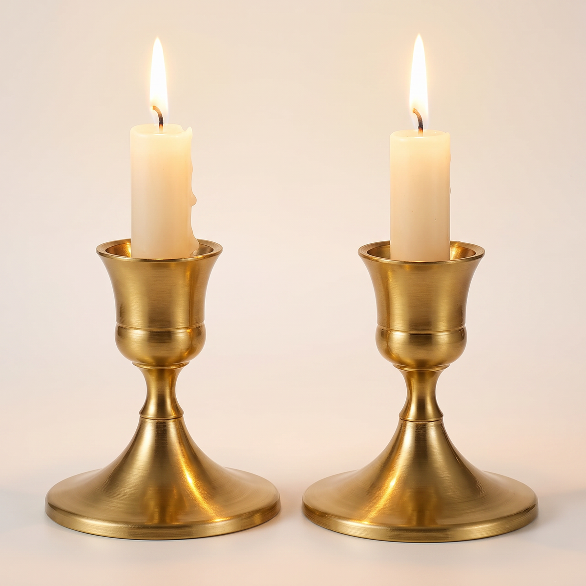 Close-up of brass gold candlestick holders showing brushed metal finish