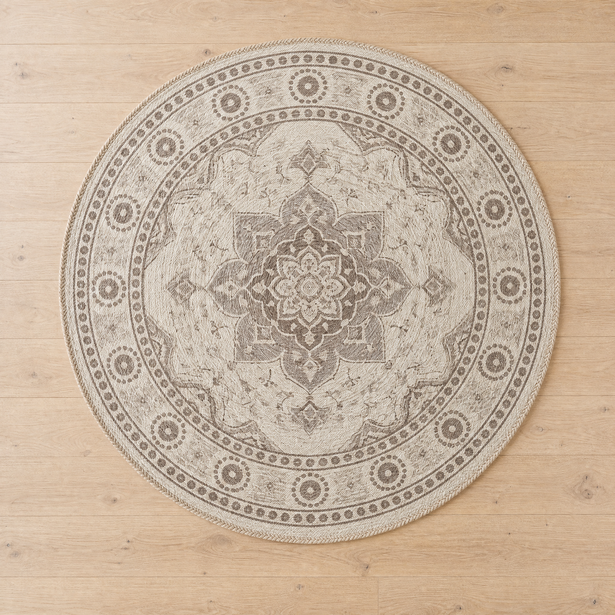 Overhead flat-lay of Round Rug Roman showing its full beige and taupe medallion pattern