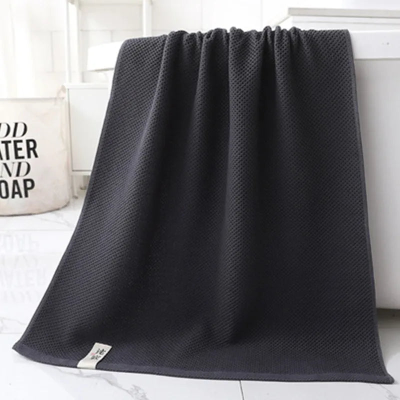 Bath Towel Júlia in charcoal hanging over a bath