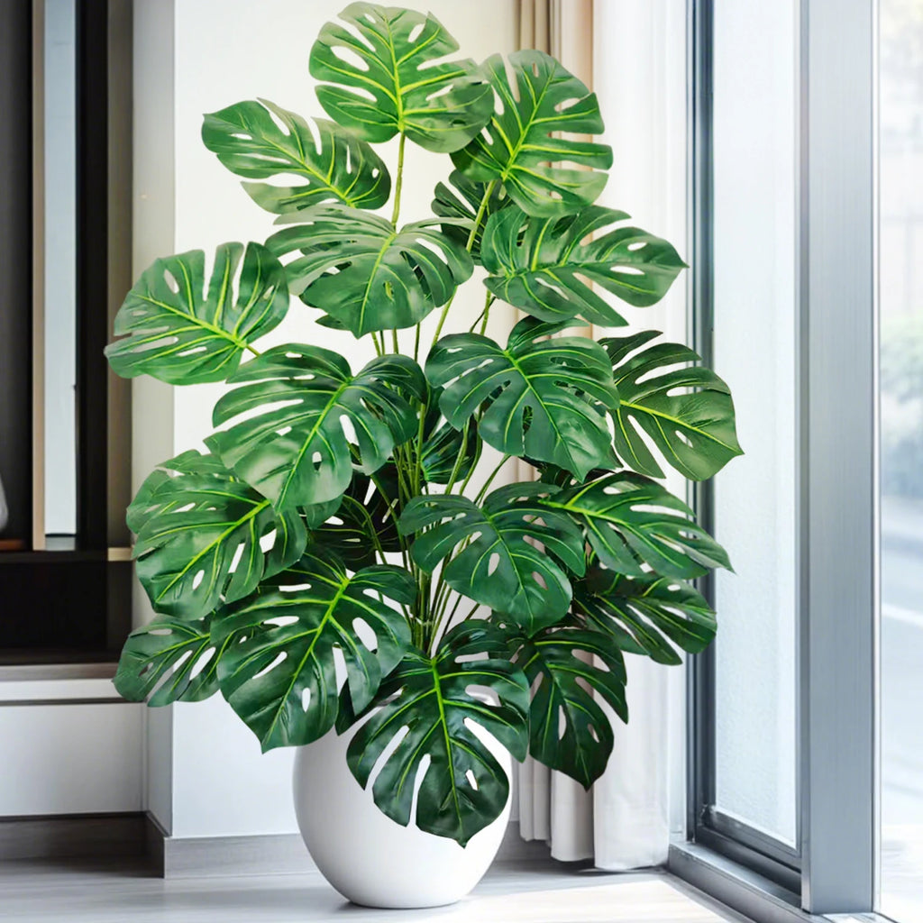 Artificial monstera Blanka in dark green by a large window