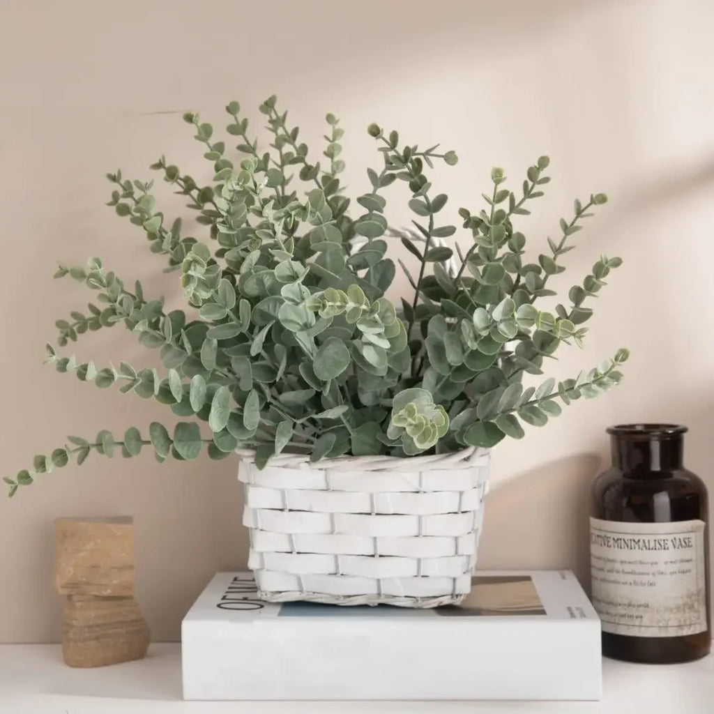 Grey green eucalyptus stems in a white woven basket on a shelf