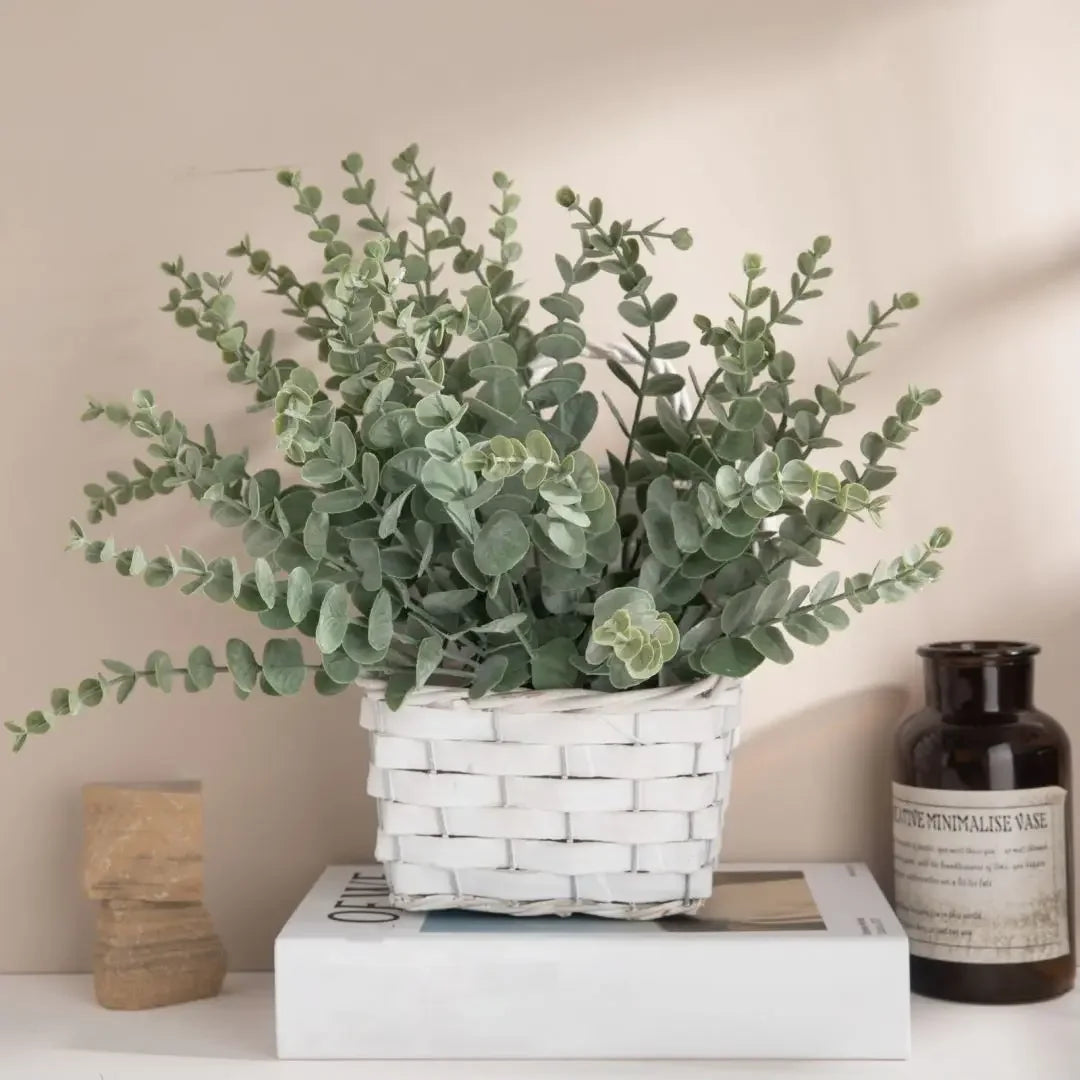 Grey green eucalyptus stems in a white woven basket on a shelf