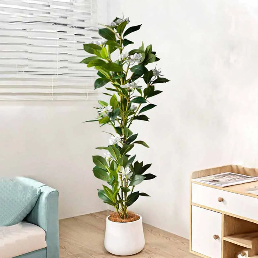 Faux flowering stem Denisa with white blossoms in a white planter in a living room