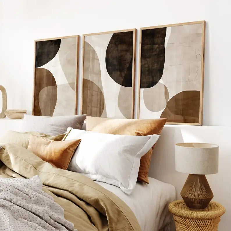 Three Umber Organic abstract canvas prints above a bed