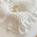 Close-up of white seersucker duvet cover Hana with a double ruffle edge