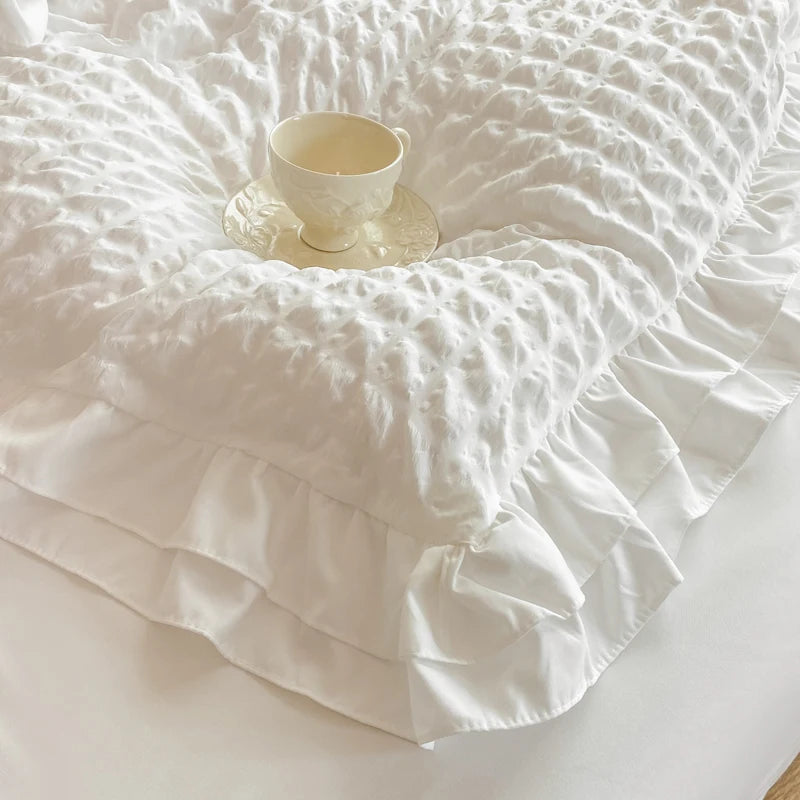 Close-up of white seersucker duvet cover Hana with a double ruffle edge