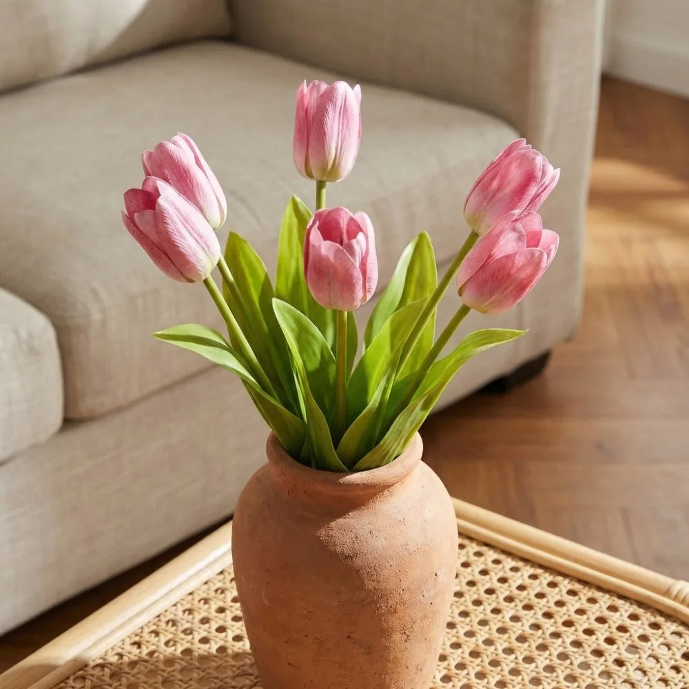 Pink real-touch tulips in a terracotta vase on a coffee table