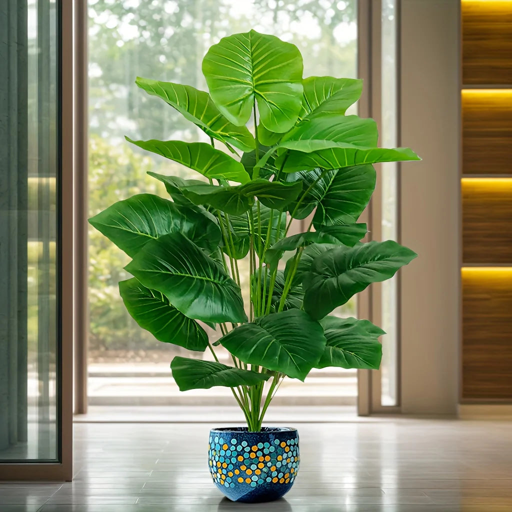 Faux tropical plant with large green leaves beside a window (pot not included)