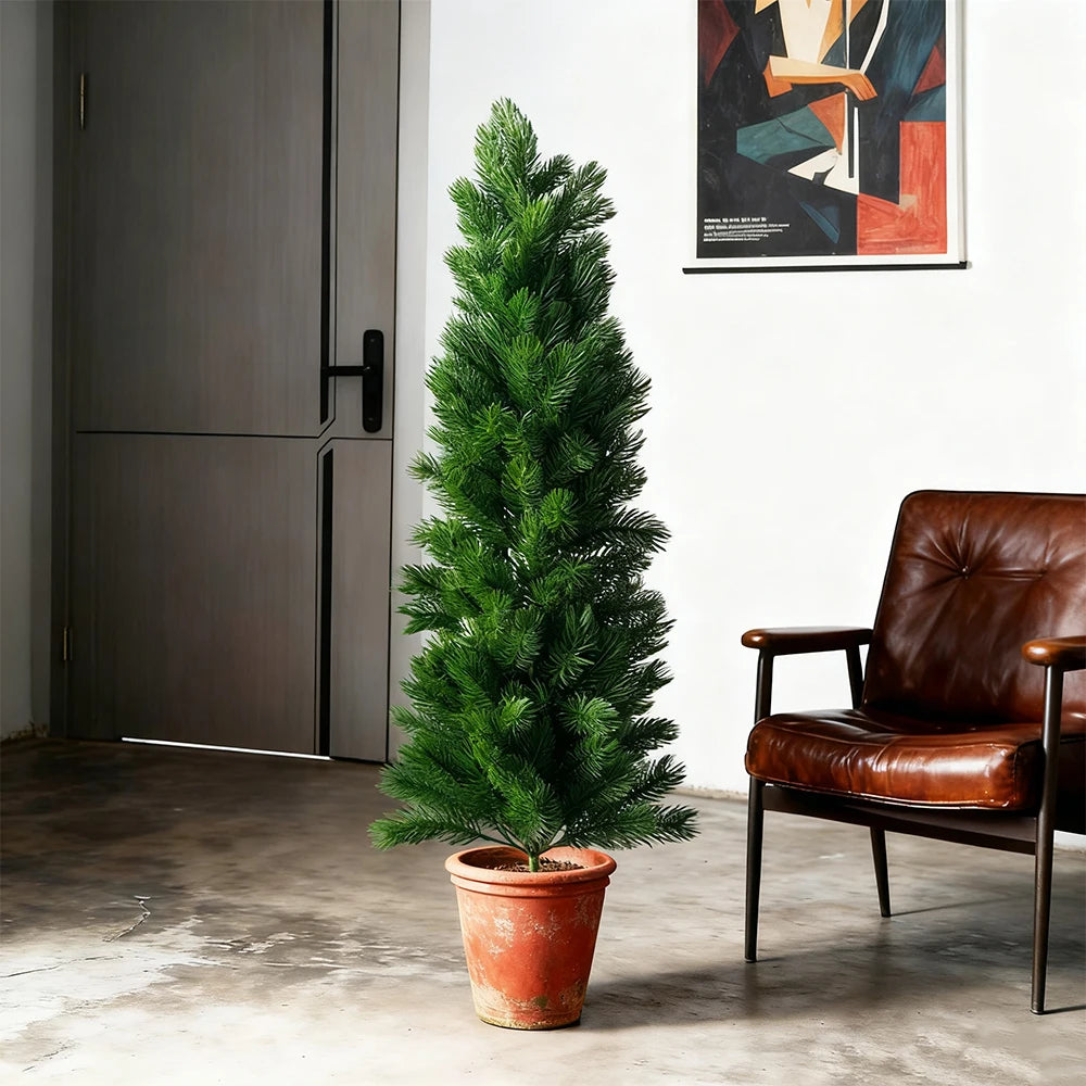 Faux pine tree Gejza in a terracotta pot beside a leather armchair