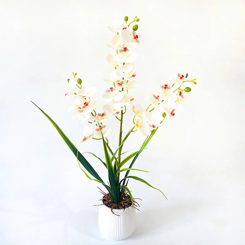 Artificial white orchid in a white ribbed pot