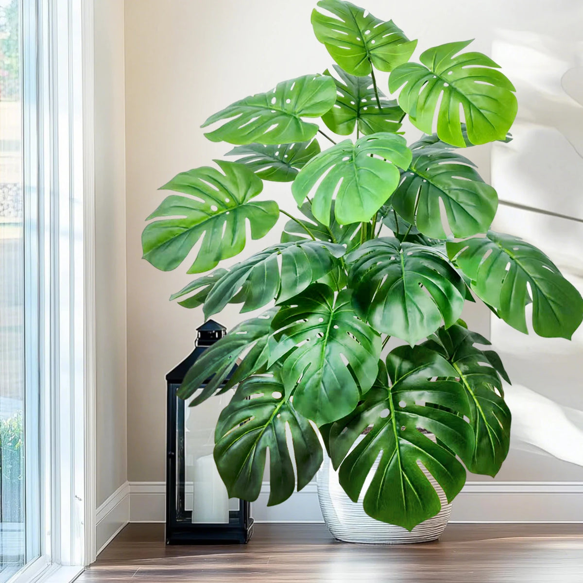 Artificial monstera Blanka in fresh green by a tall window