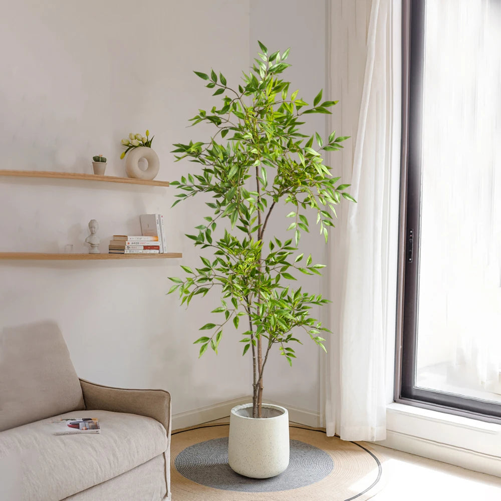 Faux nandina stem Elvíra in a cream planter next to a sofa