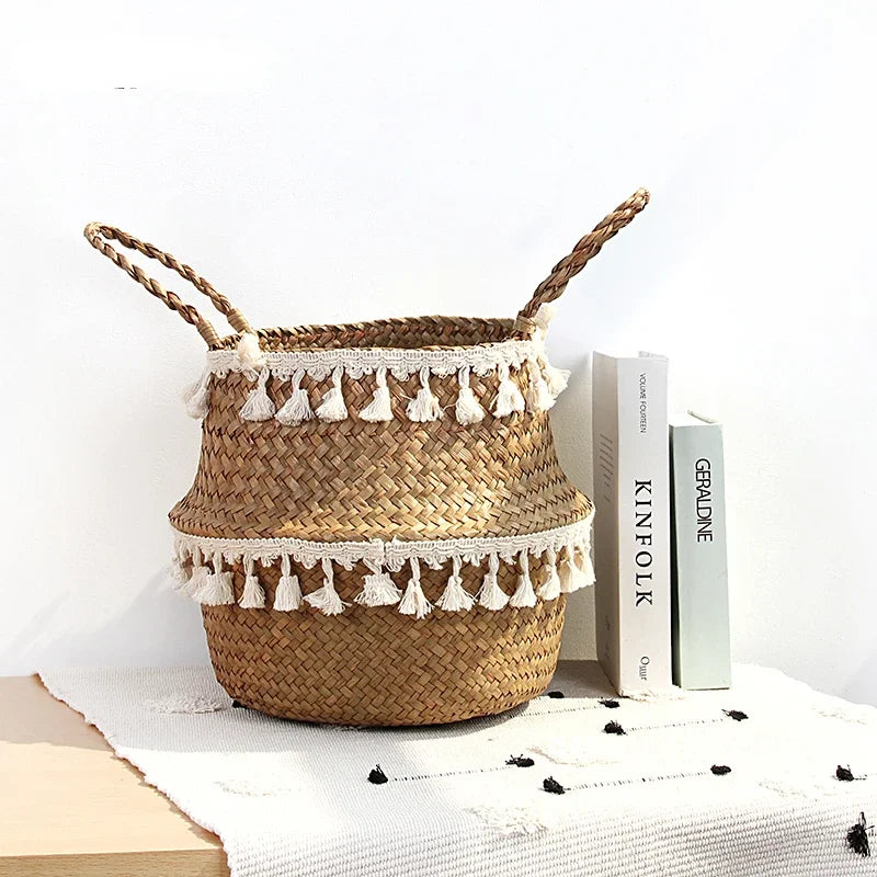 Seagrass belly basket with white tassel trim on a shelf next to books