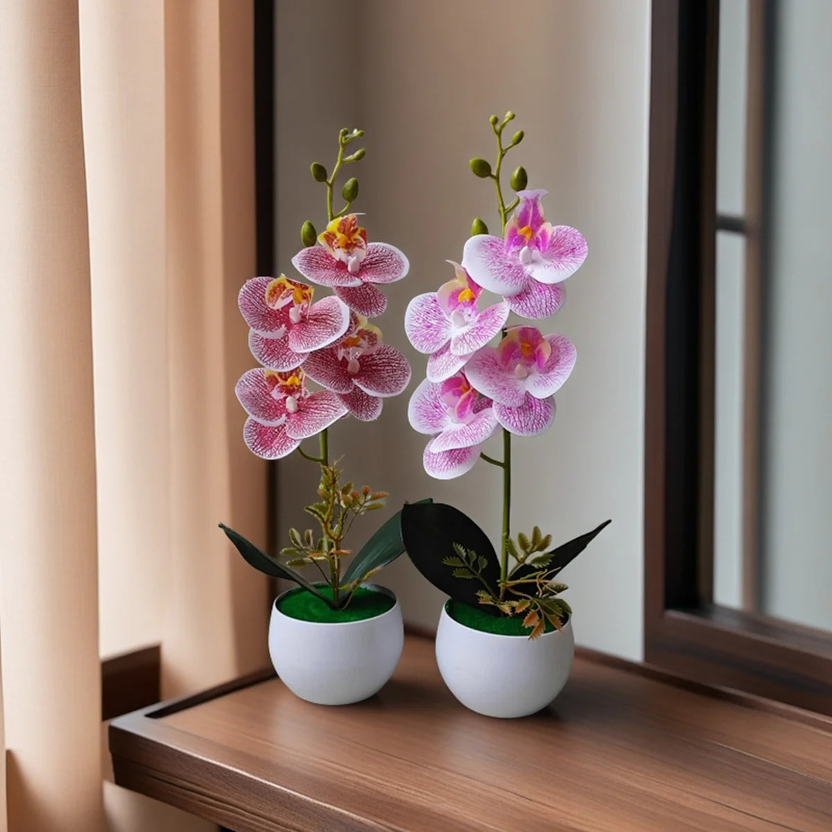 Two artificial pink orchids in white pots on a wooden table
