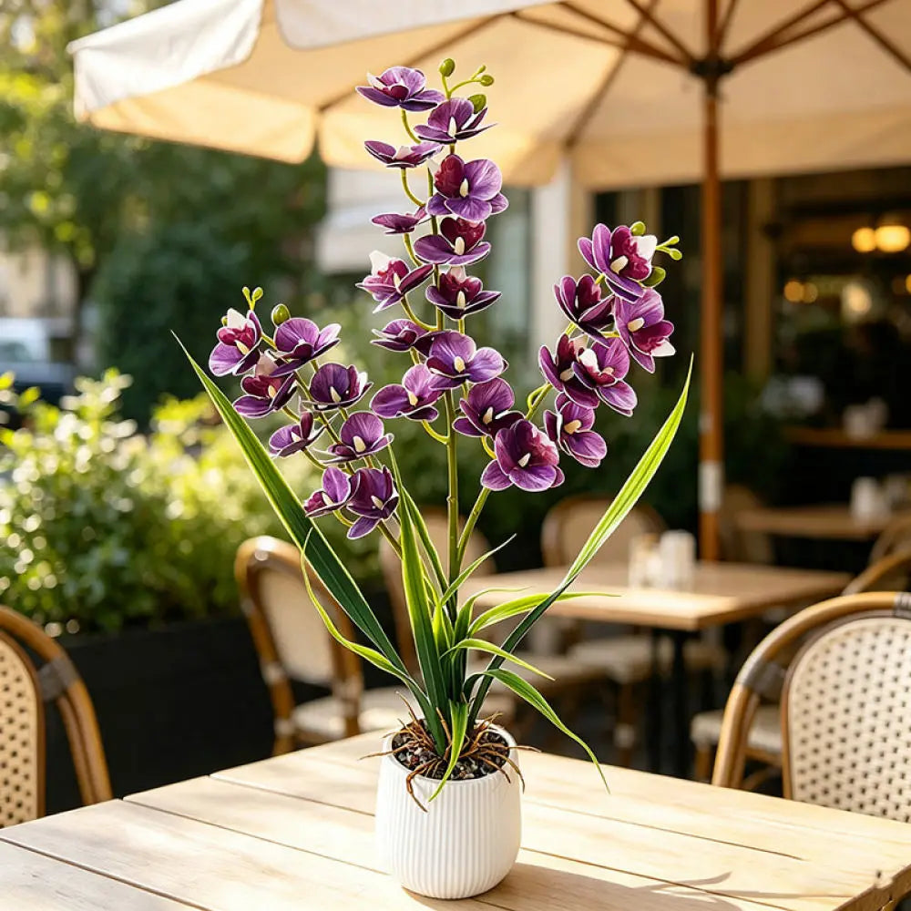 Artificial purple orchid in a white pot on a table