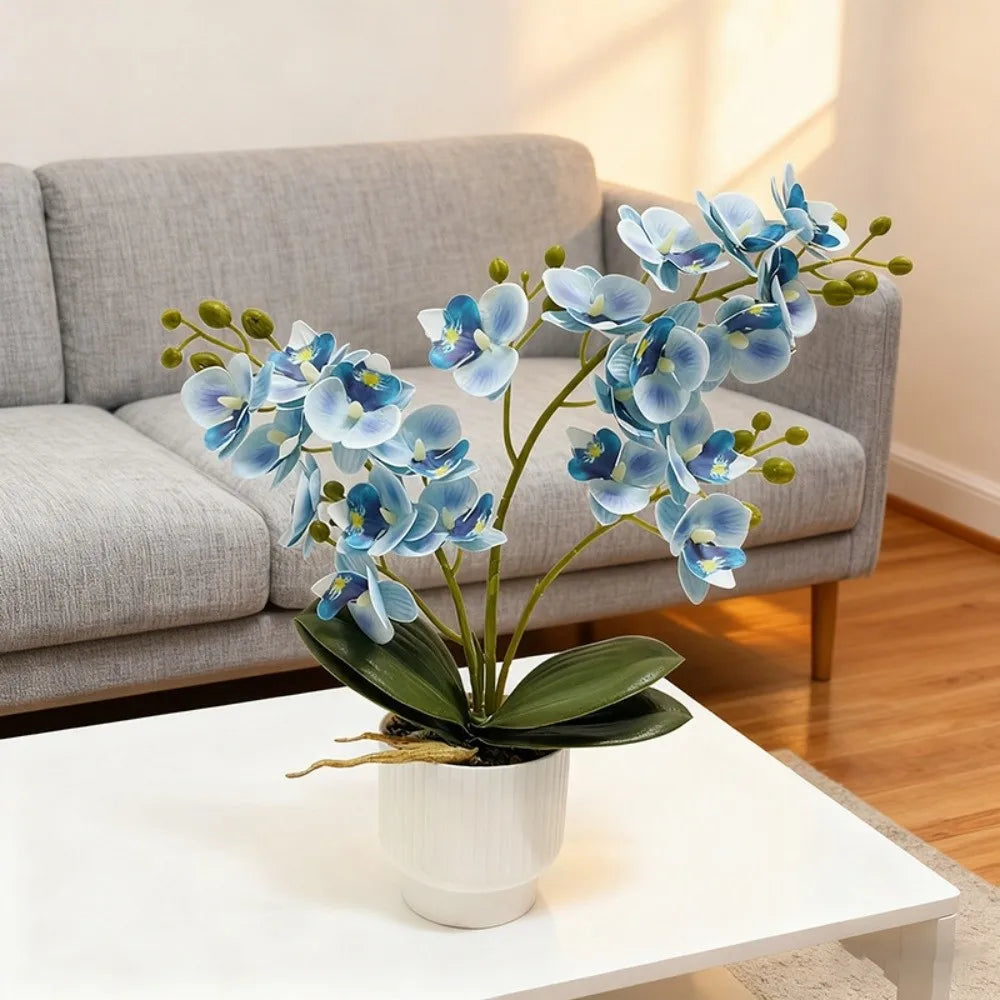 Artificial blue butterfly orchid in a white pot on a coffee table by a sofa