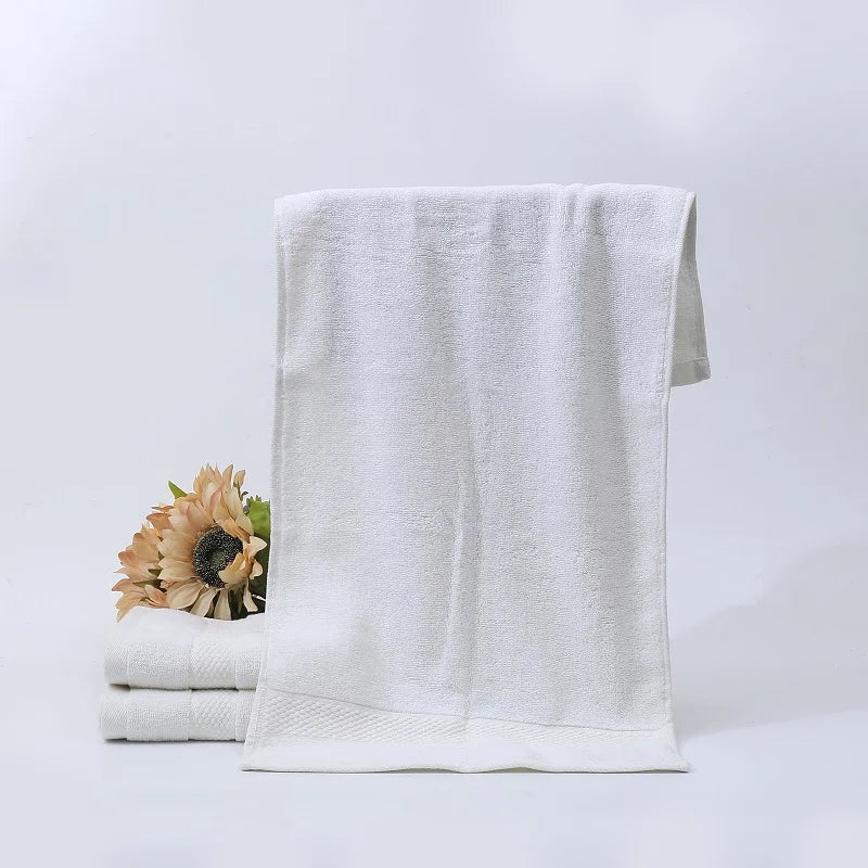 Hand Towel Set Miroslava, white cotton towel hanging over a stack of towels