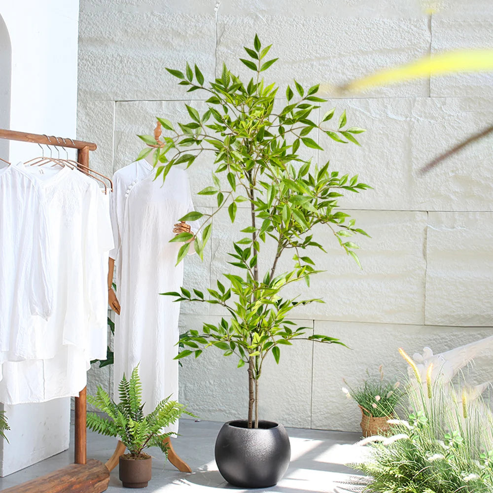 Faux nandina stem Elvíra in a black planter on a bright terrace
