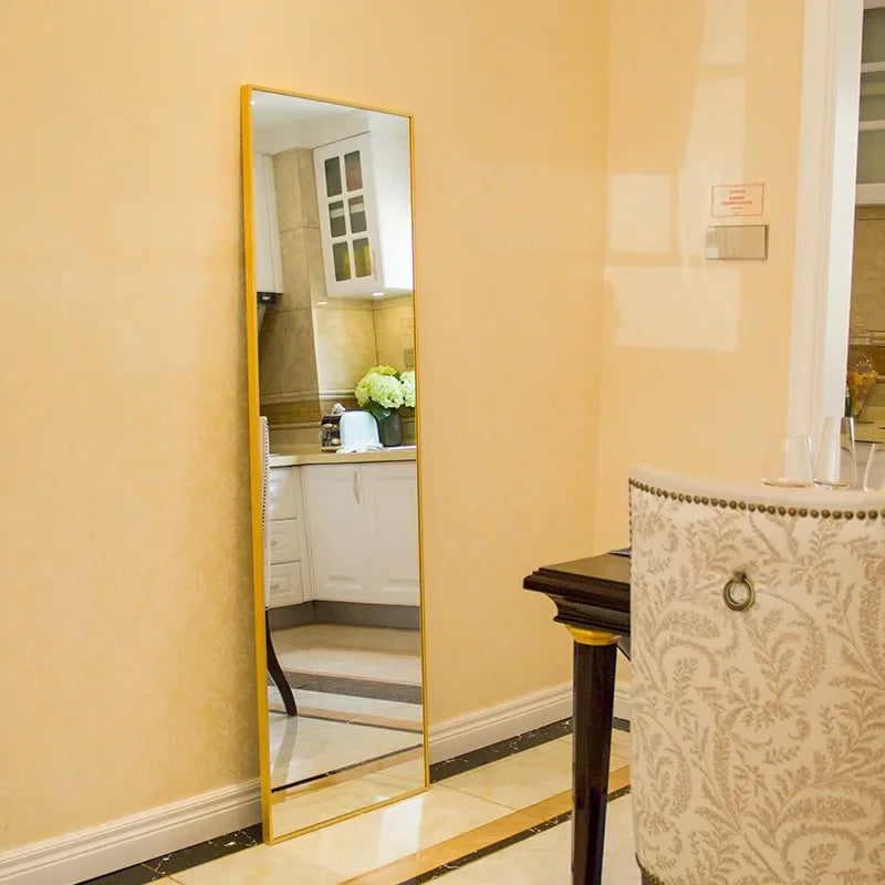 Standing Mirror Ivona with a slim gold frame in a warm room