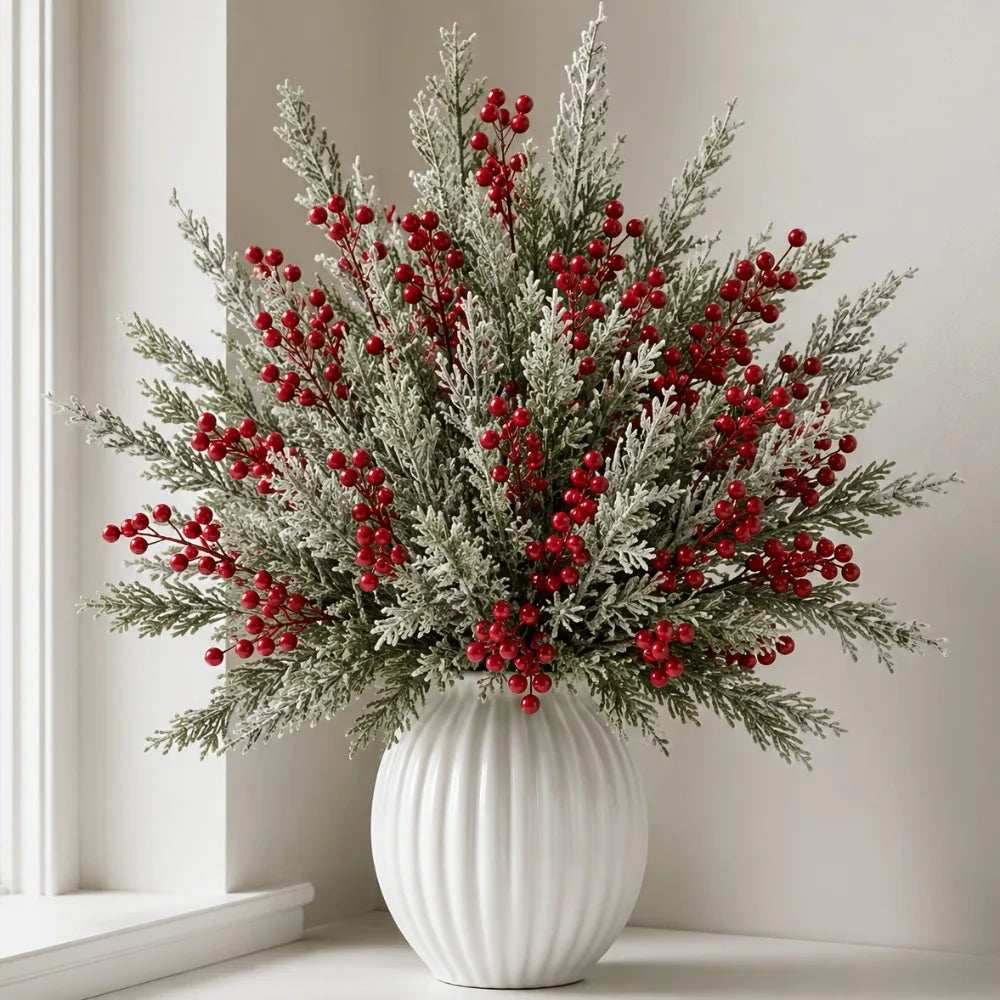 Snowy pine and red berry stems in a white ribbed vase on a windowsill