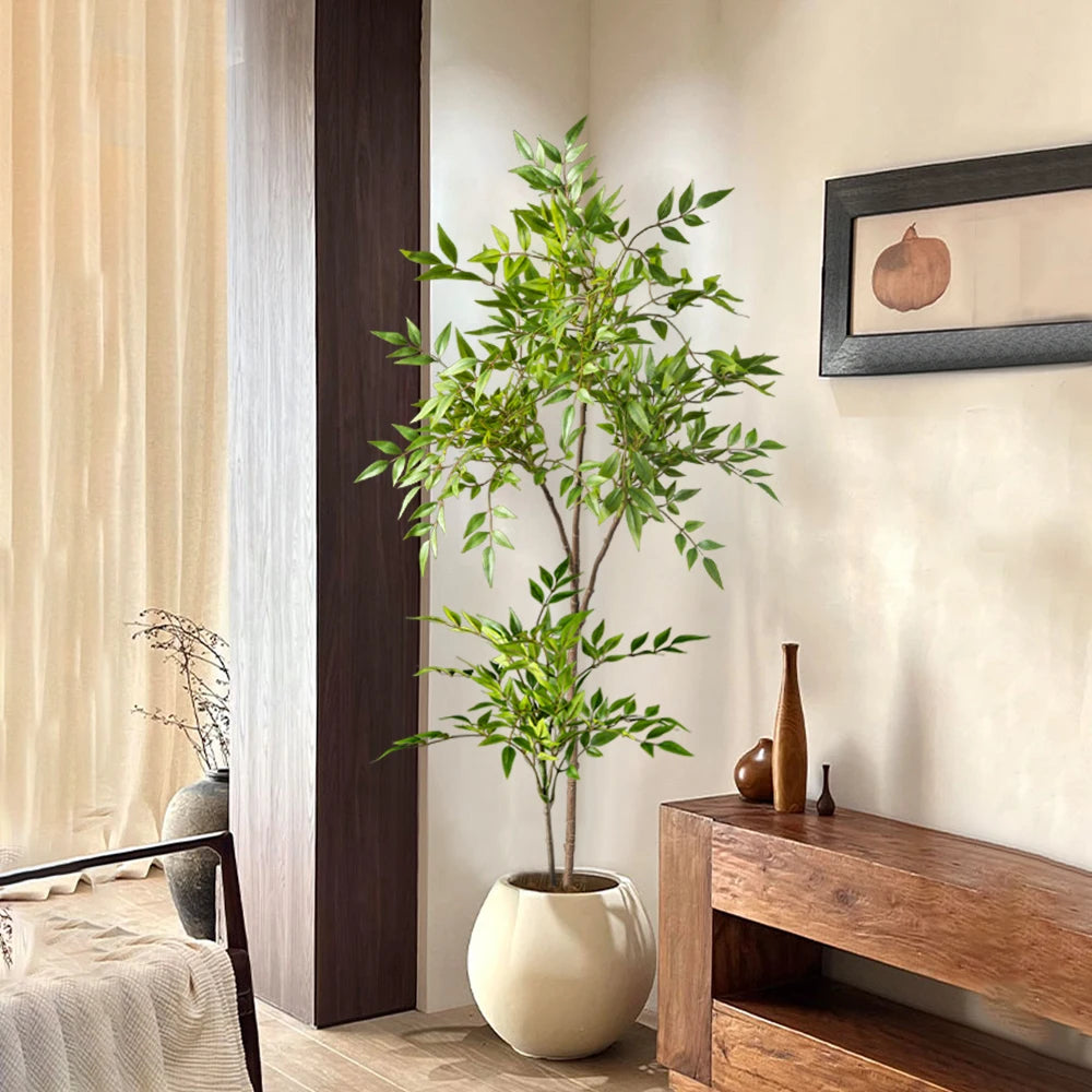 Faux nandina stem Elvíra in a round planter beside a sideboard