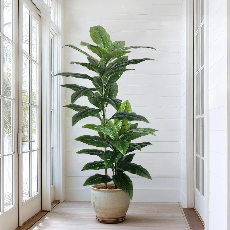 Tall artificial plant Andrea by a window in a white pot