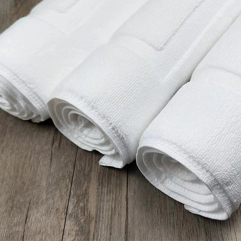 Bath Mat Jarmila, rolled white cotton mats on a wooden floor