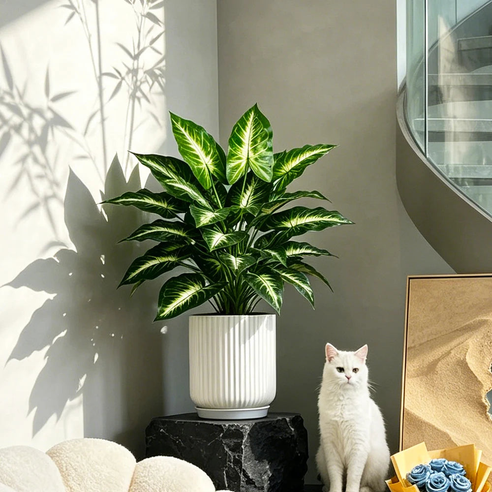 Small faux leaf plant in a ribbed white pot on a pedestal