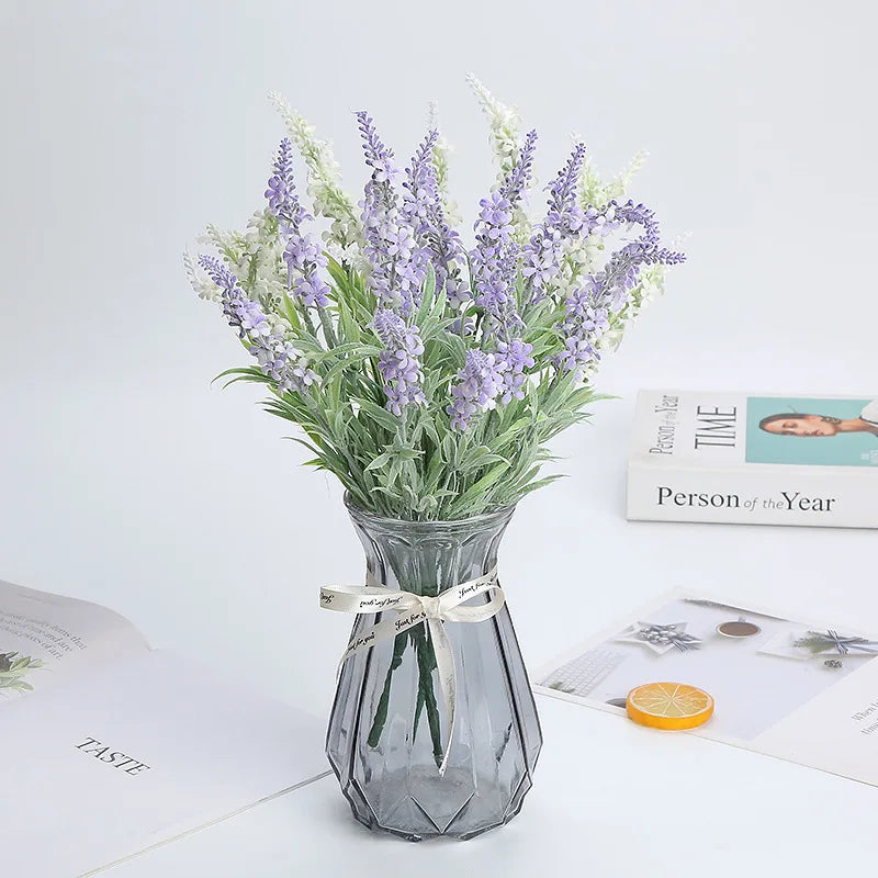 Artificial lavender bunches in a glass vase on a table