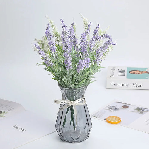 Artificial lavender bunches in a glass vase on a table