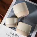 Three cream ceramic cups with an unglazed natural base, seen from above