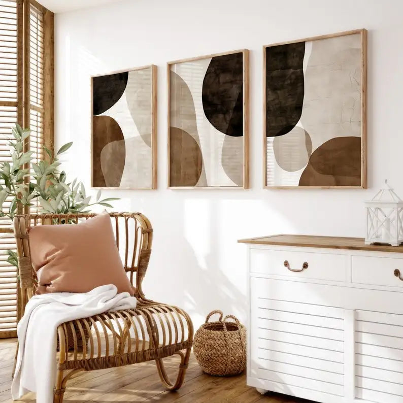 Three Umber Organic abstract canvas prints above a rattan chair