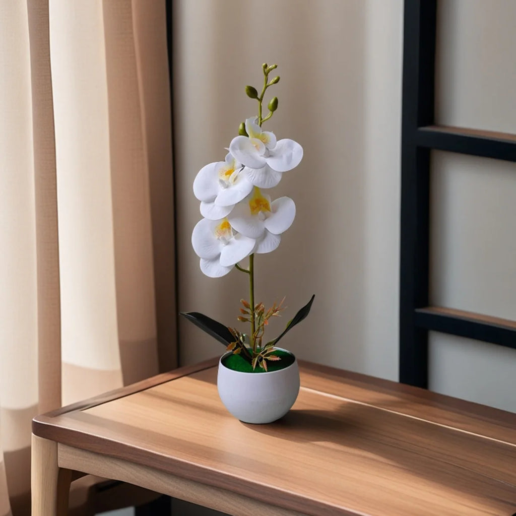 Artificial white orchid with yellow centre in a white pot