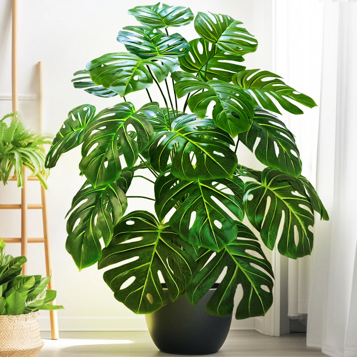 Artificial monstera Blanka in dark green beside a plant ladder