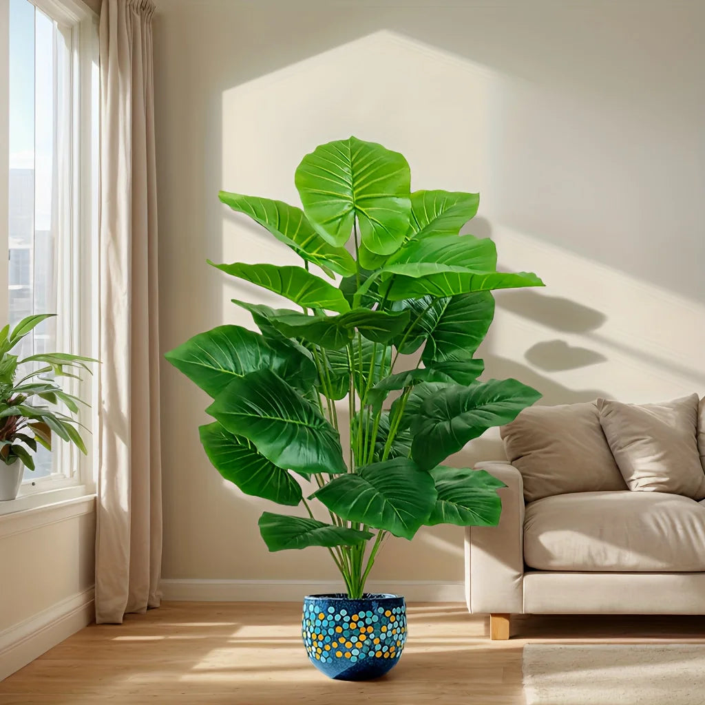 Faux tropical plant with large green leaves in a bright living room (pot not included)