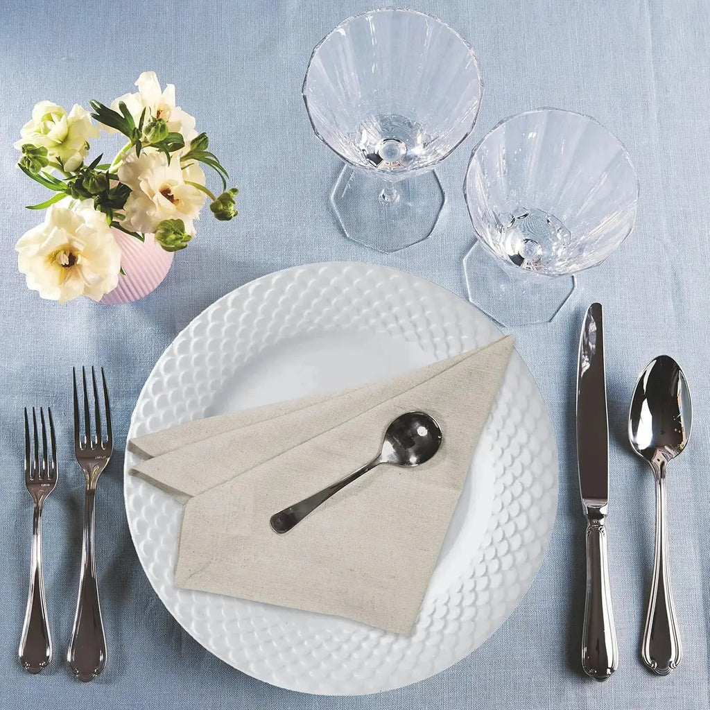 Natural cloth napkin on a plate with cutlery on a set table