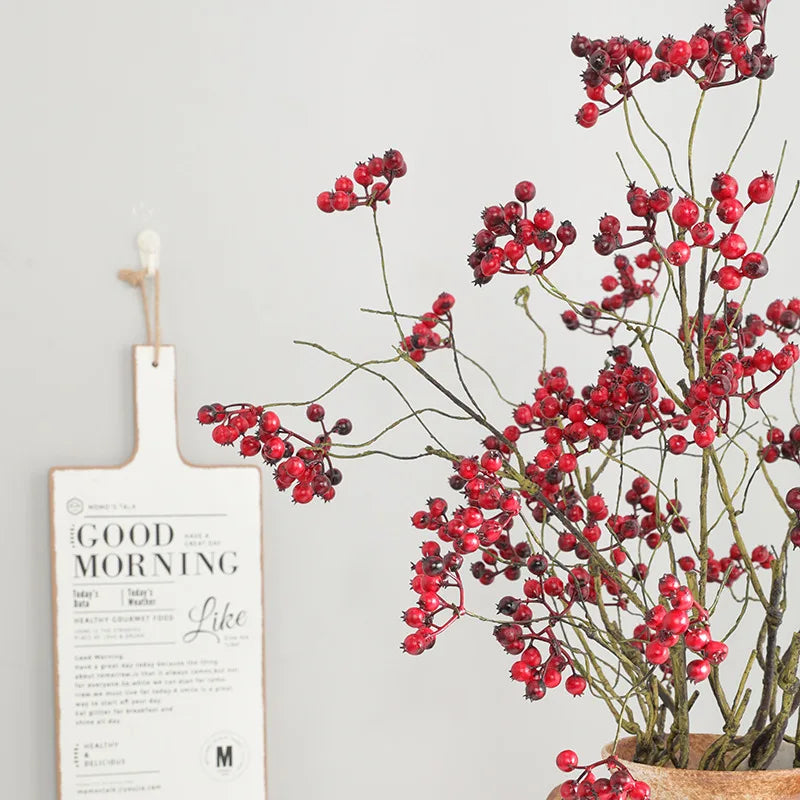 Red faux cranberry branches in a vase with a woven base