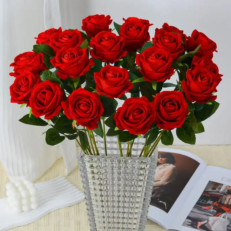 Red velvet roses in a glass vase on a side table