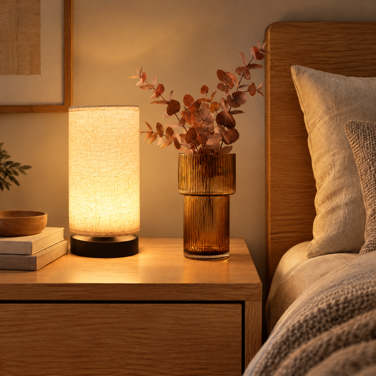 Bedside Set styled on a nightstand with a lit table lamp and amber glass vase