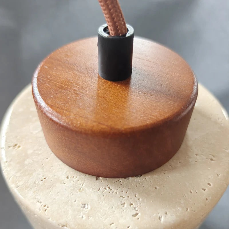 Close-up of the walnut cap on the travertine shade of Pendant Light Dana