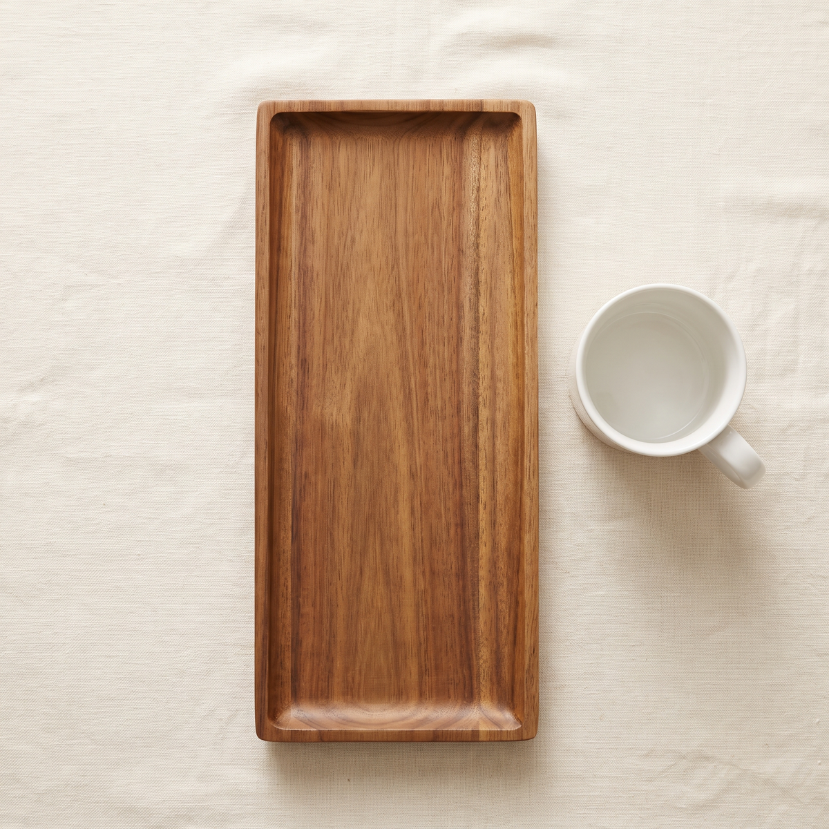 Wooden Tray Oliver Big shown next to a coffee mug for scale reference