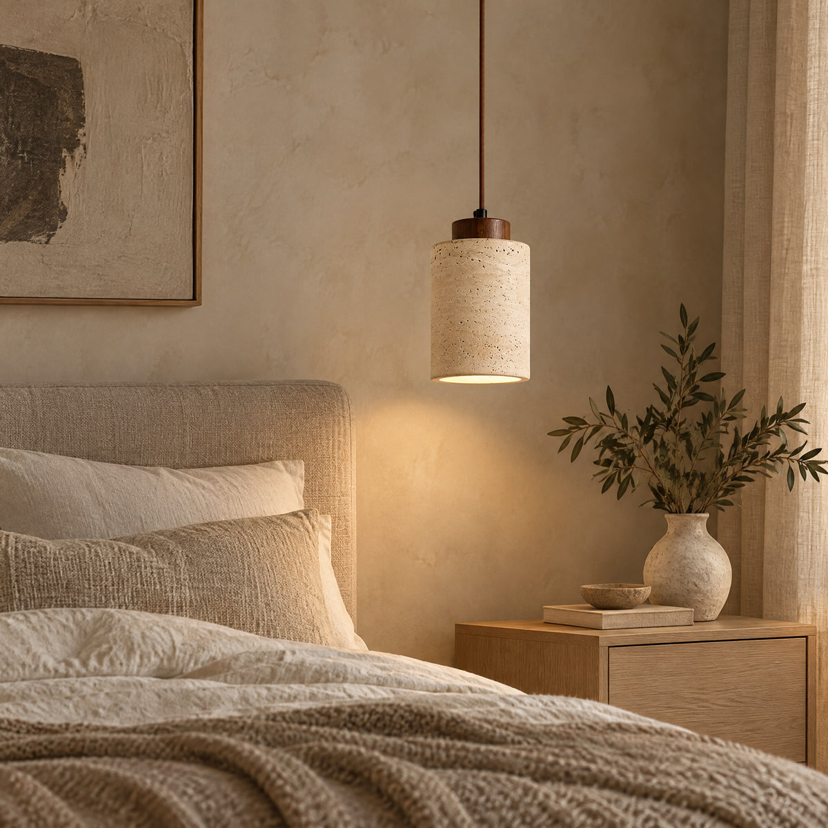 Pendant Light Tibor, a tall travertine pendant with walnut cap beside a bed