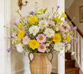 Wildflower sprays in a woven vase by a staircase